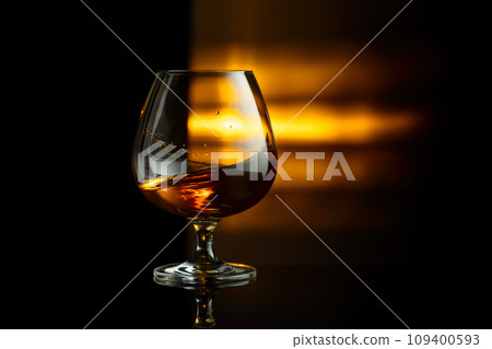 Snifter of brandy on a black background. Snifter of brandy on a black background. 109400593