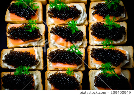 Closeup of natural black caviar served on crackers on black background, texture of fresh sturgeon caviar macro photo. 109400949