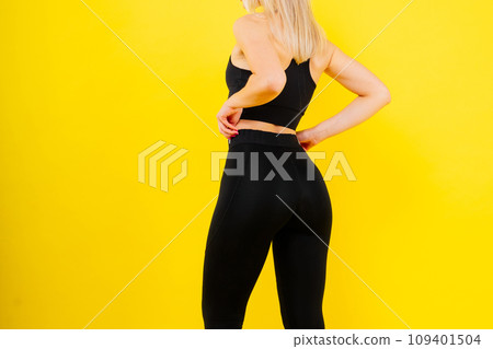 Beautiful young woman dressed in sports uniform, posing in studio on a yellow red dark background. Beautiful young woman dressed in sports uniform, posing in studio on a yellow red dark background. 109401504