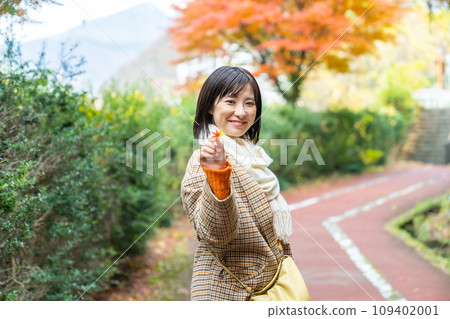 一個女人站在秋天的落葉中 一個女人站在秋天的落葉中 109402001