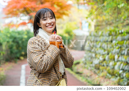 一個女人站在秋天的落葉中 一個女人站在秋天的落葉中 109402002