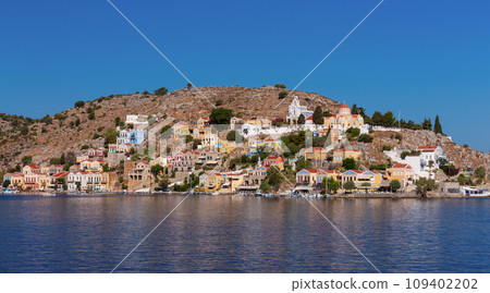 Multi-colored facades of houses in the village Symi on a sunny day. 109402202