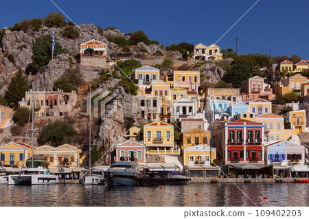 Multi-colored facades of houses in the village Symi on a sunny day. Multi-colored facades of houses in the village Symi on a sunny day. 109402203