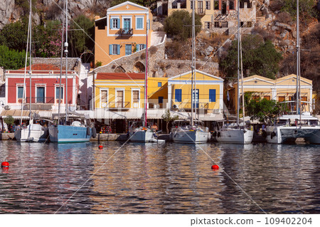 Multi-colored facades of houses in the village Symi on a sunny day. 109402204