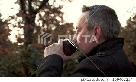 Male entrepreneur drinks coffee waiting for business meeting in town park Male entrepreneur drinks coffee waiting for business meeting in town park 109402234
