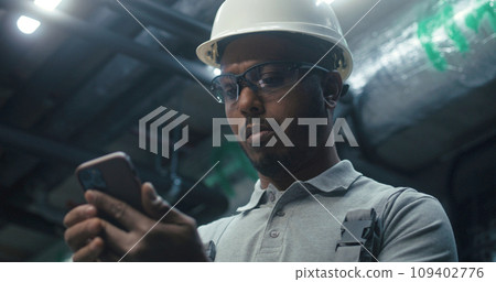 Close up of African American engineer using phone 109402776