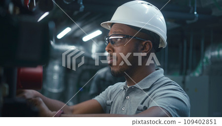 African American worker inspects and adjusts energy system African American worker inspects and adjusts energy system 109402851