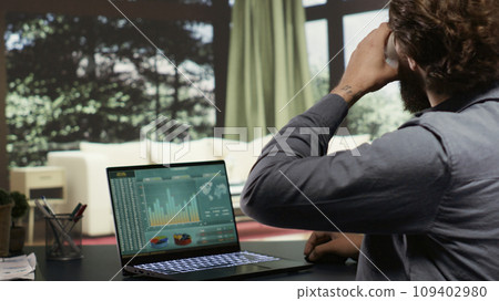 Wealthy shareholder connects on laptop to support his staff from his high end alpine retreat. Business owner examines worldwide profit statistics for banking administration at deluxe lodging. 109402980