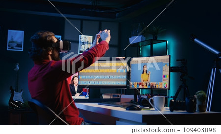 Photo editor retouching photographs with editing software in high tech virtual reality application. Photographer browsing through photoshoot images using futuristic VR technology headset Photo editor retouching photographs with editing software in high tech virtual reality application. Photographer browsing through photoshoot images using futuristic VR technology headset 109403098