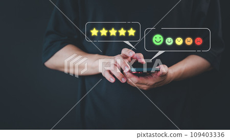 Customer use a smartphone give point 5 stars and smile face icon for feedback review satisfaction service opinion and testimonial on application. Online customer review satisfaction feedback survey. 109403336