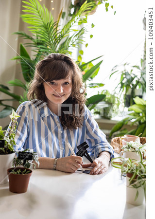 Domestic woman variegated monstera growing care writing sign plate names transplant seedlings 109403451