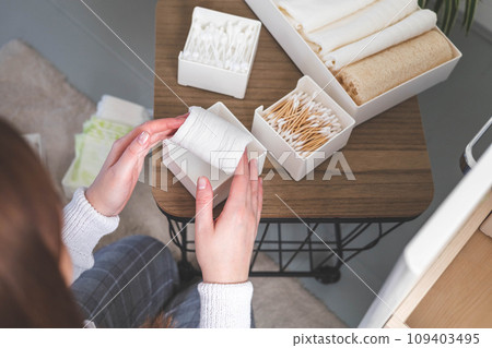 Top view of woman hands neatly organizing bathroom amenities and toiletries in drawer in bathroom. 109403495
