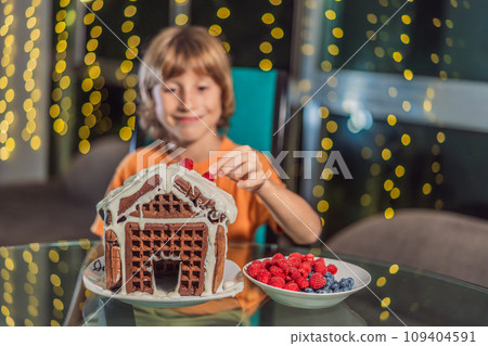 Immerse in festive delight as a boy crafts boy crafting an unconventional gingerbread house, infusing Christmas with unique creativity and festive cheer. A sweet scene of seasonal bonding and culinary Immerse in festive delight as a boy crafts boy crafting an unconventional gingerbread house, infusing Christmas with unique creativity and festive cheer. A sweet scene of seasonal bonding and culinary 109404591