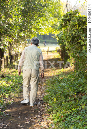 一位老人在公園散步的後視圖 109406344