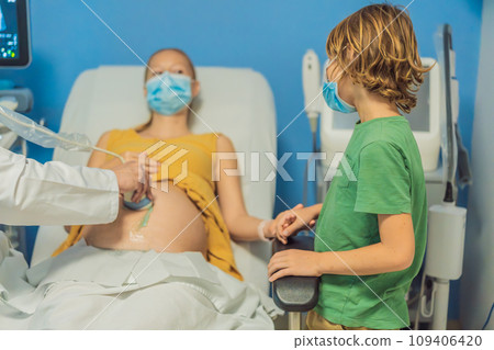a pregnant mother's ultrasound visit, sharing the excitement with her son who eagerly awaits the arrival of his baby brother. A heartwarming portrayal of family bonds and the anticipation of new 109406420