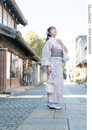 一位年輕女子穿著和服在城裡散步 109407792