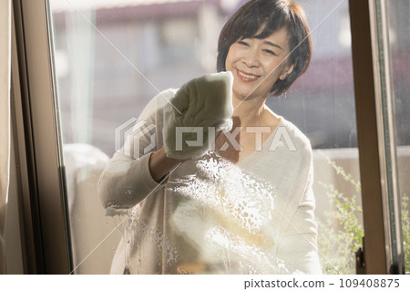 A woman in her 50s cleaning windows A woman in her 50s cleaning windows 109408875