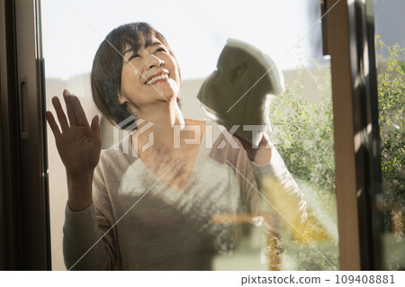 一名50多歲的婦女正在清潔窗戶 109408881