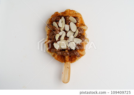croissant waffles decorated with whipped cream, strawberries, nuts, banana and blueberries 109409725