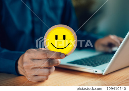 Hands holding happy smile face, satisfaction, customer review, good feedback rating, think positive, assessment, world mental health day, Calm mood, good mental health, good mood. 109410540