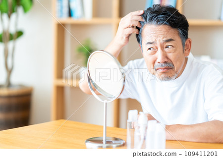 A senior man who is concerned about his hairline. A senior man who is concerned about his hairline. 109411201