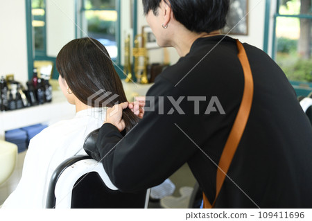 男理髮師正在幫女顧客做頭髮造型 109411696