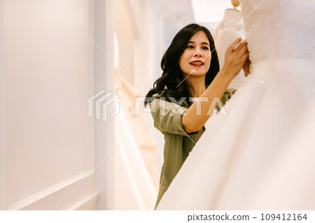 Female bridal store owner work in wedding studio shop.  109412164