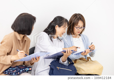 Woman filling out a clipboard in the waiting room 109412184