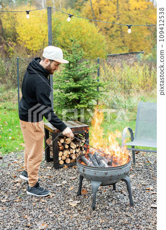 A man lights a barbecue in nature 109412538