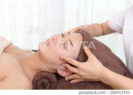 A woman receiving a facial massage A woman receiving a facial massage 109412543