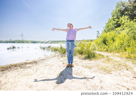 Embracing Nature: Open-Armed Stance by the Lake Embracing Nature: Open-Armed Stance by the Lake 109412924