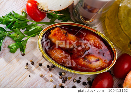 Stuffed squid in American sauce with greens and tomatoes at table 109413162