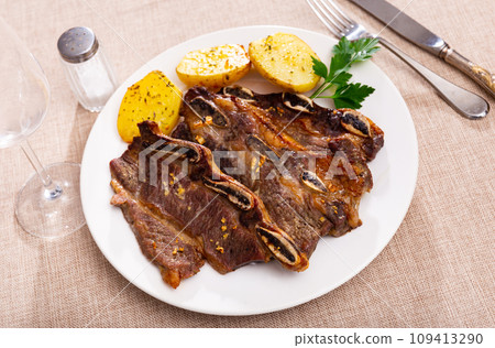 Grilled beef ribs churrasco with fried potatoes and greens Grilled beef ribs churrasco with fried potatoes and greens 109413290