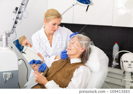 Cosmetologist and mature woman after face lifting procedures 109413883