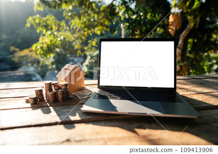Laptop and money placed on a wooden table Laptop and money placed on a wooden table 109413906