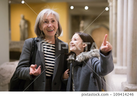 Elderly female tutor showing tween girl ancient sculptures in museum Elderly female tutor showing tween girl ancient sculptures in museum 109414246