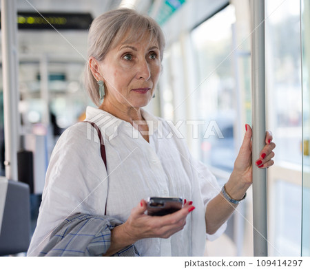 Woman with smartphone standing in tram 109414297