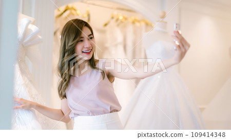 Bride and groom choosing wedding dress in shop. Bride and groom choosing wedding dress in shop. 109414348