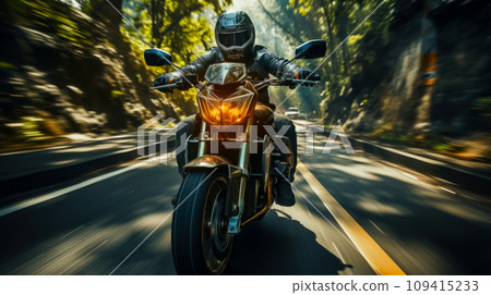 A motorcyclist rushes along a winding mountain road through a gorge, the idea of motorcycle travel and adventure during vacation, blurred background 109415233