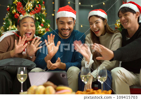 Group of diverse ethnicity young people enjoy celebrating a Christmas and New Year party together with a lot of foods and drinks. Friends celebrate Christmas and New Year festival and drink a wine. 109415703