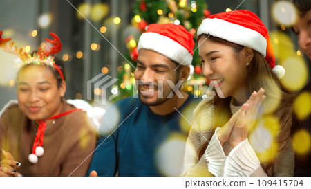 Group of diverse ethnicity young people enjoy celebrating a Christmas and New Year party together with a lot of foods and drinks. Friends celebrate Christmas and New Year festival and drink a wine. 109415704