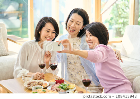 A woman taking pictures of the party with her smartphone A woman taking pictures of the party with her smartphone 109415948