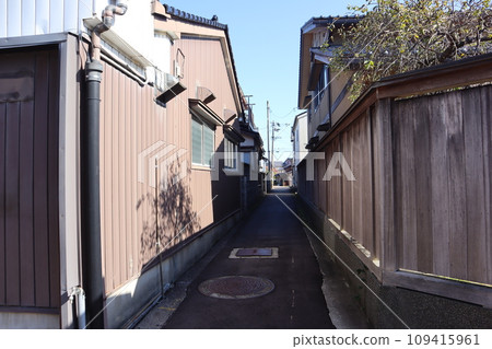 Scenery of a townscape with a blue sky, wooden fences, and alleys lined with private houses Scenery of a townscape with a blue sky, wooden fences, and alleys lined with private houses 109415961