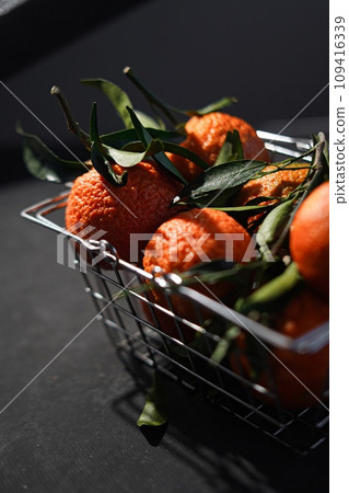lot of mandarins in metal shopping basket  109416339