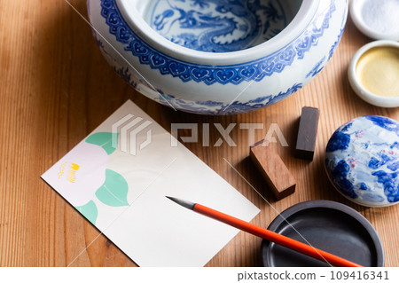 Write seasonal news on camellia postcards with a brush 109416341