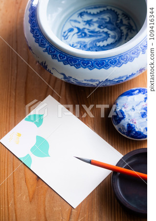 Write seasonal news on camellia postcards with a brush 109416344