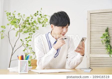 High school boy studying using smartphone at home High school boy studying using smartphone at home 109416519