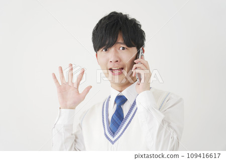 Surprised high school boy while calling on smartphone, white background 109416617