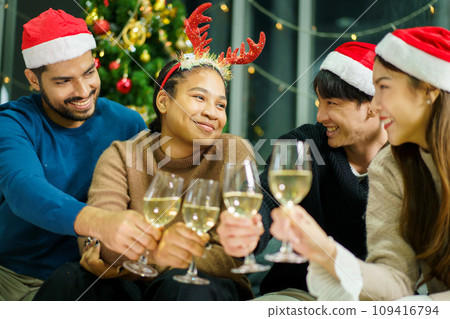 Group of diverse ethnicity young people enjoy celebrating a Christmas and New Year party together with a lot of foods and drinks. Friends celebrate Christmas and New Year festival and drink a wine. Group of diverse ethnicity young people enjoy celebrating a Christmas and New Year party together with a lot of foods and drinks. Friends celebrate Christmas and New Year festival and drink a wine. 109416794