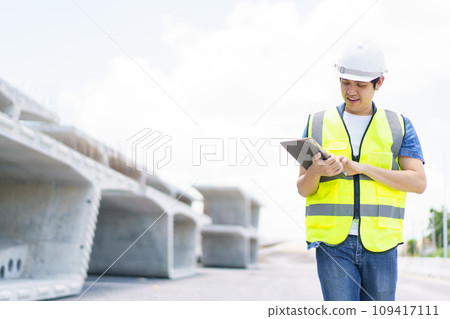 Professional senior Asian civil engineer working at the heavy infrastructure construction site, civil engineer - foreman inspecting the segmentation construction bridge. Professional senior Asian civil engineer working at the heavy infrastructure construction site, civil engineer - foreman inspecting the segmentation construction bridge. 109417111